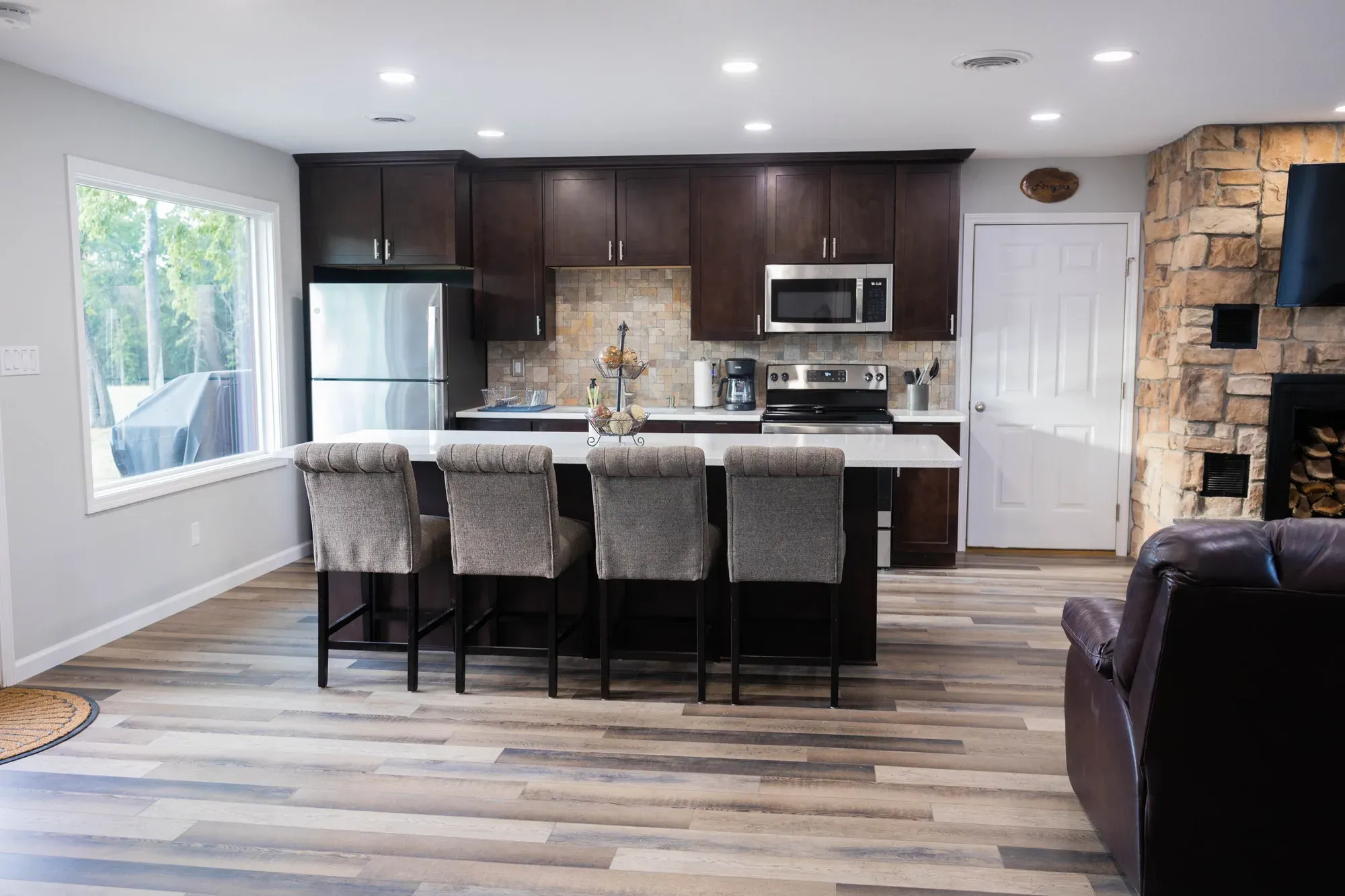 Open kitchen with a large island, bar stools and stainless steel appliances
