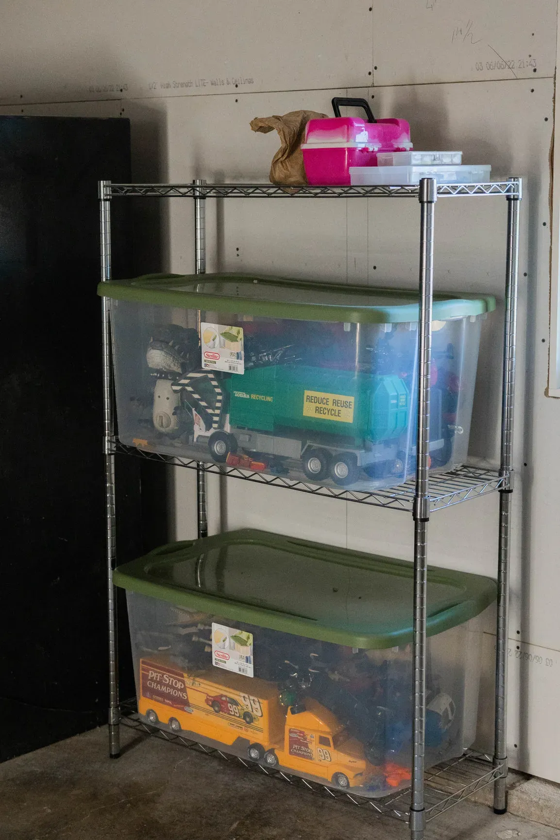 Tackle box on a shelf above bins of kids’ toys at the farmhouse